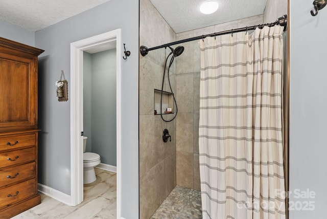 full bath with toilet, a tile shower, and a textured ceiling