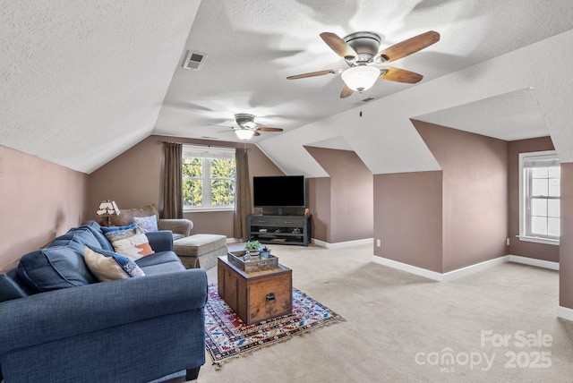 living room featuring a textured ceiling, light colored carpet, visible vents, baseboards, and vaulted ceiling