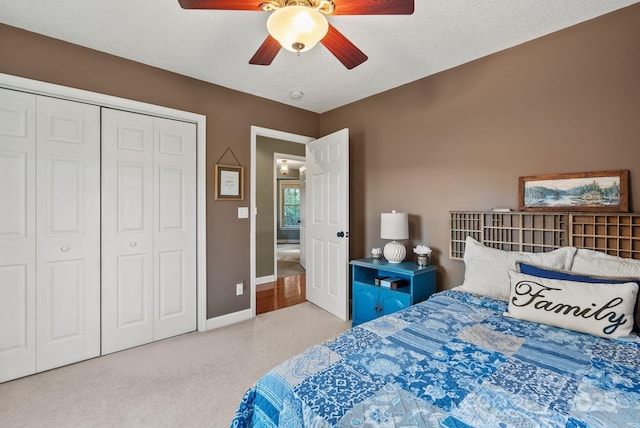 carpeted bedroom with a closet, ceiling fan, a textured ceiling, and baseboards