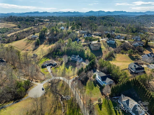 aerial view with a wooded view and a mountain view