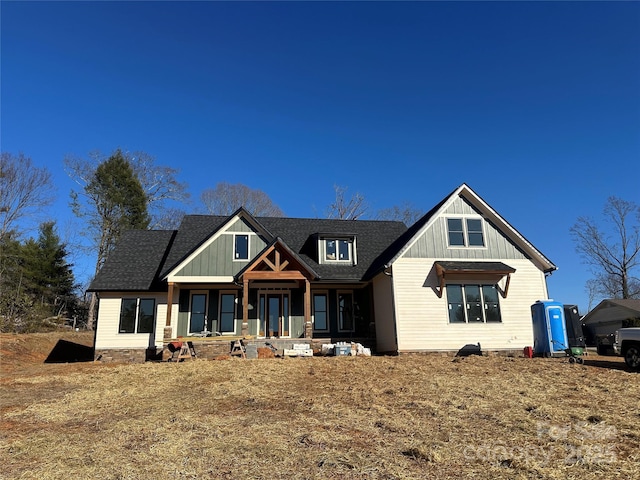 view of front facade with a porch, board and batten siding, and a shingled roof