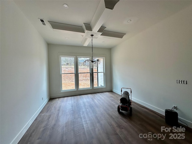 spare room featuring dark wood-style flooring, visible vents, and baseboards