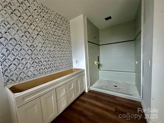 full bath featuring a shower and wood finished floors