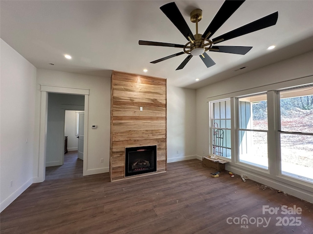 unfurnished living room featuring recessed lighting, dark wood-style flooring, and a tiled fireplace