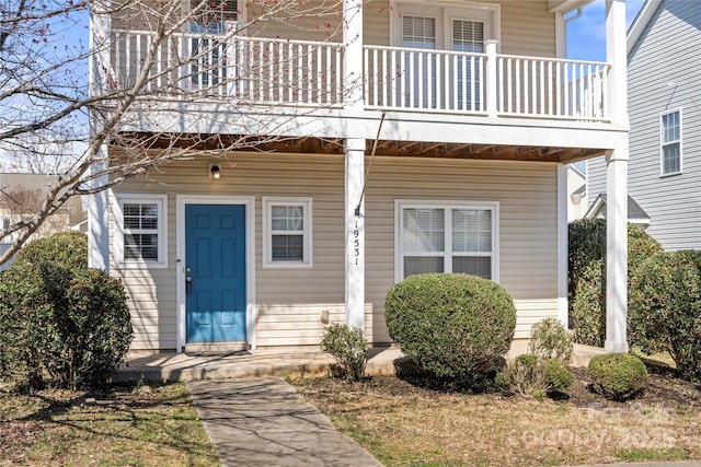 entrance to property featuring a porch and a balcony