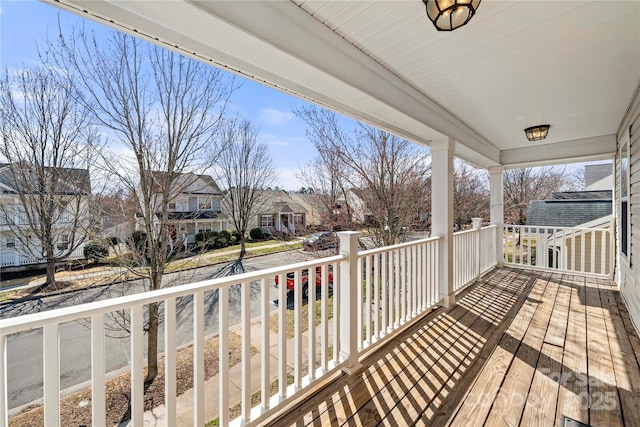 wooden terrace with a residential view and a porch