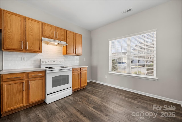 kitchen with white electric stove, under cabinet range hood, visible vents, light countertops, and backsplash