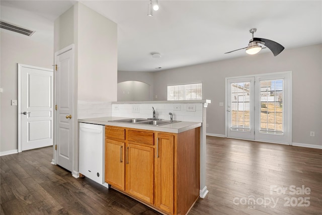 kitchen with visible vents, dishwasher, dark wood-style floors, a peninsula, and a sink