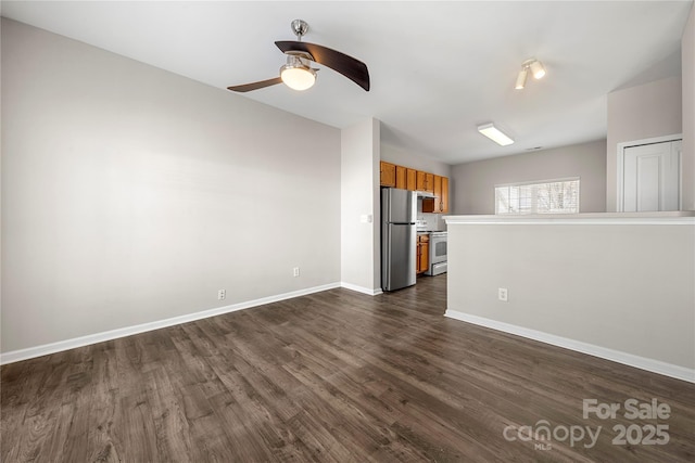 unfurnished living room featuring dark wood-style floors, ceiling fan, and baseboards