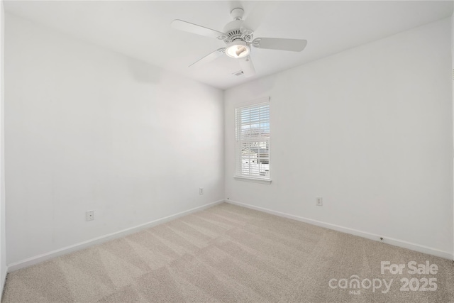 spare room with light carpet, baseboards, and a ceiling fan