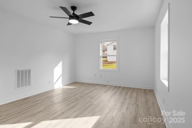 unfurnished room featuring light wood-type flooring, baseboards, visible vents, and a ceiling fan