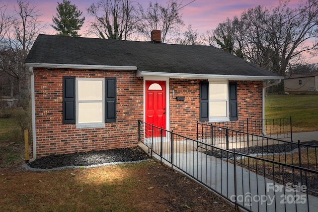 ranch-style home featuring brick siding, a chimney, and a shingled roof