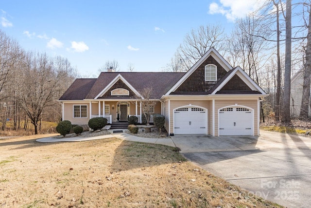 view of front of property with a garage, concrete driveway, a chimney, a porch, and a front yard