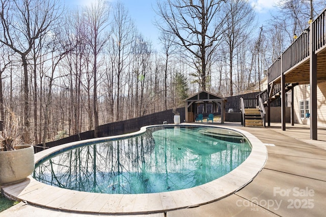 outdoor pool with stairs, a deck, a patio area, and fence