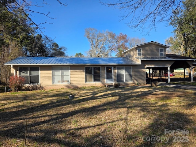 view of front of property featuring metal roof and a front lawn