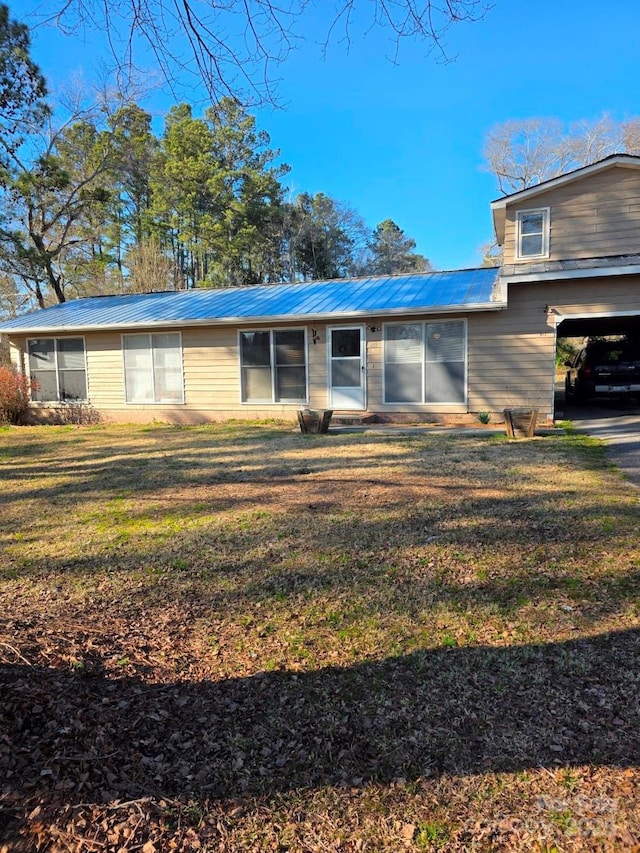 view of front of property featuring metal roof and a front yard