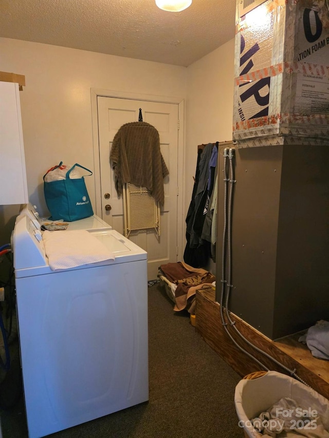 laundry area featuring a textured ceiling, laundry area, carpet floors, heating unit, and washer / dryer