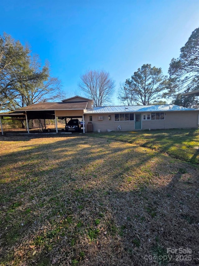 exterior space featuring a standing seam roof, metal roof, a carport, and a front yard