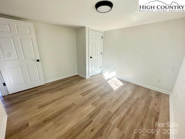 unfurnished bedroom with light wood-style floors and baseboards