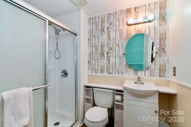 bathroom featuring toilet, a shower stall, wooden walls, and vanity