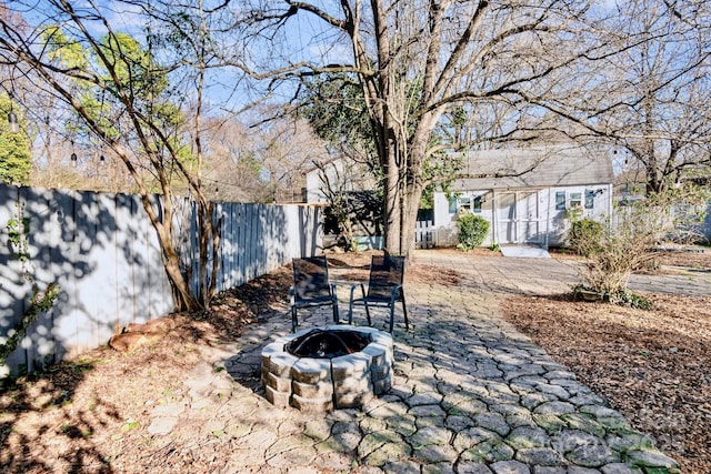 view of patio with fence private yard and a fire pit