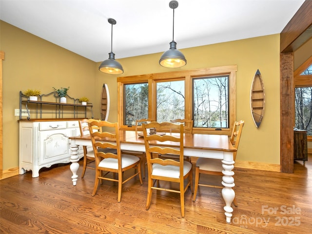 dining space with baseboards and wood finished floors