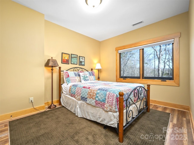 bedroom with baseboards, visible vents, and dark wood-style flooring