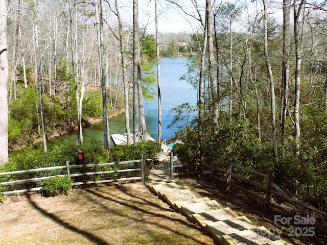 view of yard featuring a water view and fence