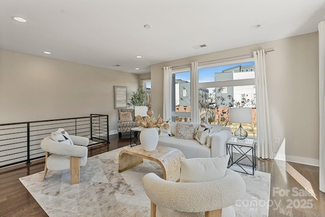 living area featuring an upstairs landing, baseboards, wood finished floors, and recessed lighting