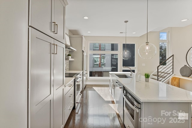 kitchen with stainless steel appliances, an island with sink, a sink, and a healthy amount of sunlight