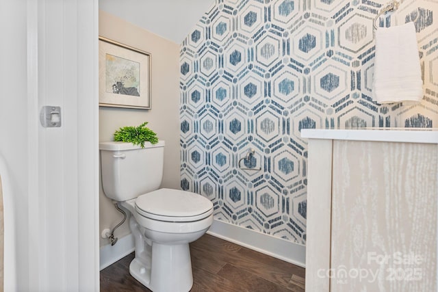 bathroom featuring toilet, baseboards, and wood finished floors