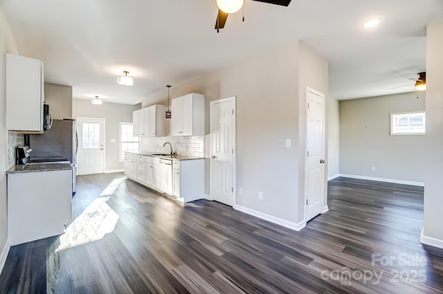 kitchen with decorative light fixtures, tasteful backsplash, white cabinetry, a sink, and dishwasher