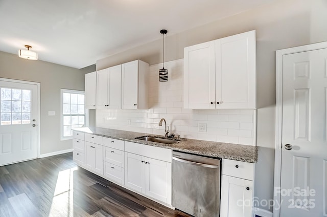 kitchen featuring pendant lighting, white cabinets, dishwasher, and a sink