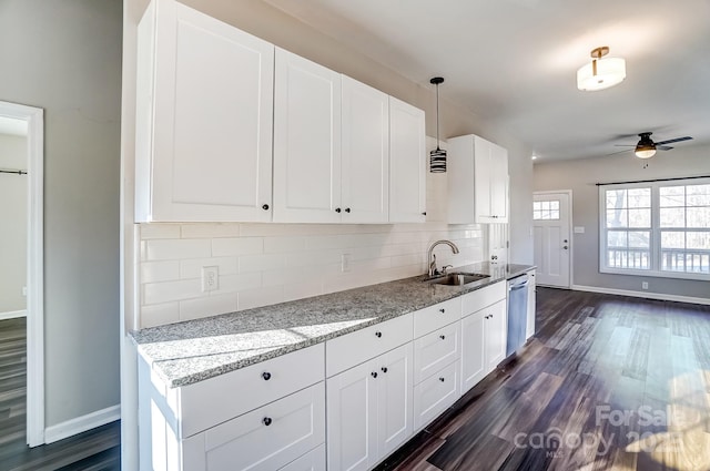 kitchen featuring a sink, white cabinetry, light stone countertops, dishwasher, and pendant lighting