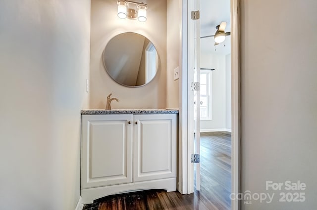 bathroom featuring vanity, baseboards, and wood finished floors