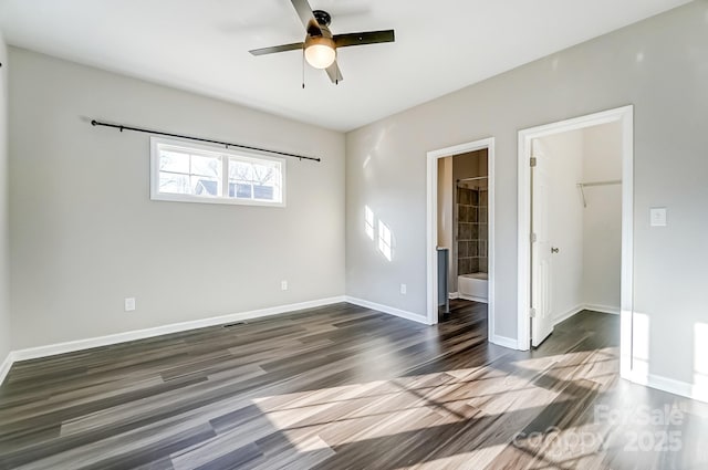 spare room with visible vents, dark wood-style flooring, a ceiling fan, and baseboards