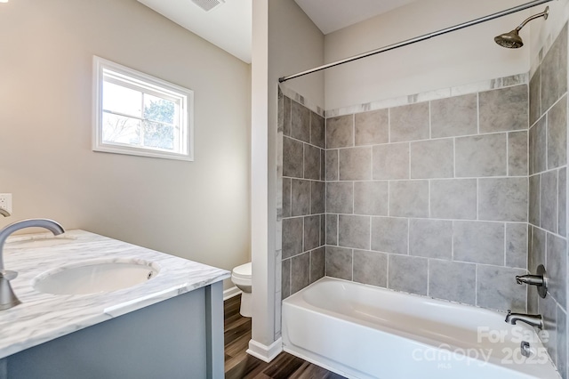 full bath featuring visible vents, toilet, wood finished floors, vanity, and shower / washtub combination