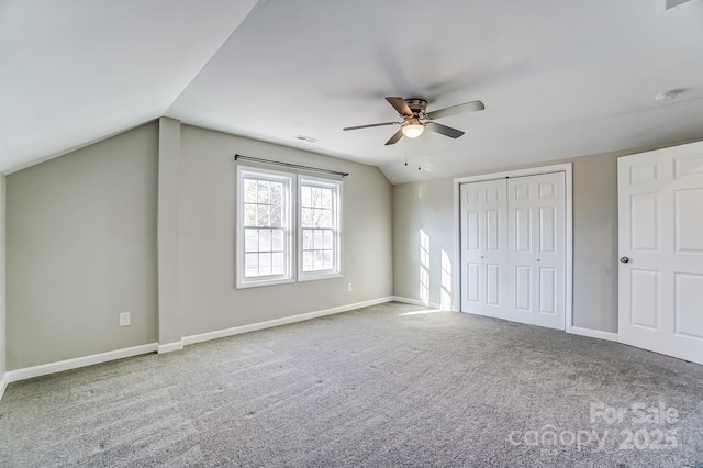 unfurnished bedroom with lofted ceiling, carpet floors, visible vents, and baseboards