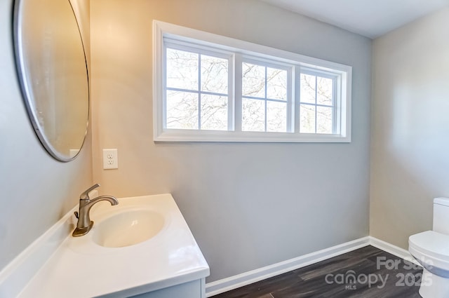 bathroom featuring baseboards, vanity, toilet, and wood finished floors