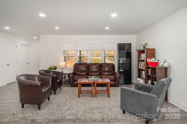 living area with recessed lighting, baseboards, and wood finished floors