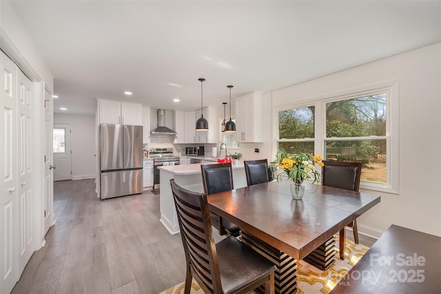 dining space featuring light wood-style floors, recessed lighting, and baseboards