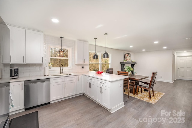 kitchen with appliances with stainless steel finishes, a sink, and white cabinetry