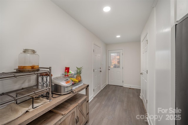 doorway with light wood-type flooring, baseboards, and recessed lighting