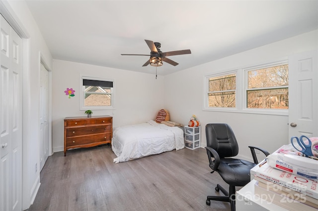 bedroom featuring a ceiling fan, baseboards, and wood finished floors