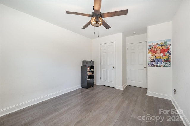 unfurnished bedroom with a ceiling fan, baseboards, and wood finished floors