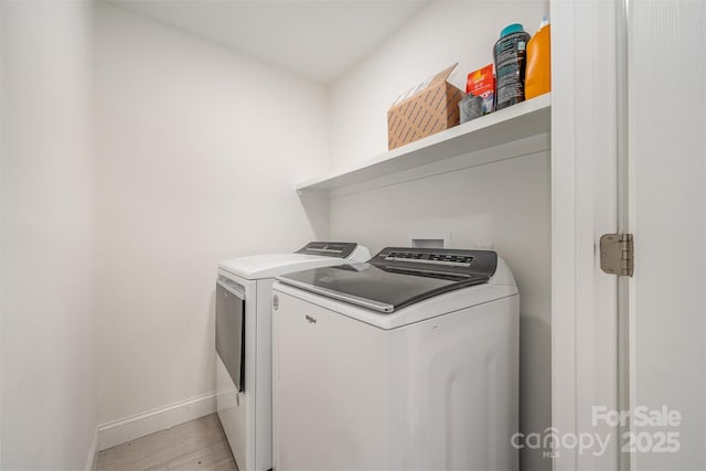 laundry area with laundry area, baseboards, light wood-style floors, and independent washer and dryer