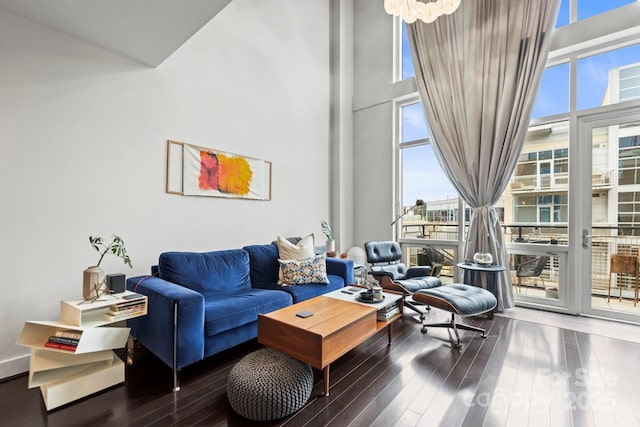 living room with hardwood / wood-style floors, a wall of windows, and a towering ceiling