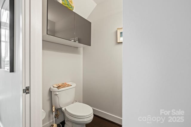 bathroom featuring toilet, baseboards, and wood finished floors