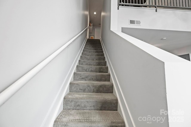 staircase featuring visible vents and carpet flooring