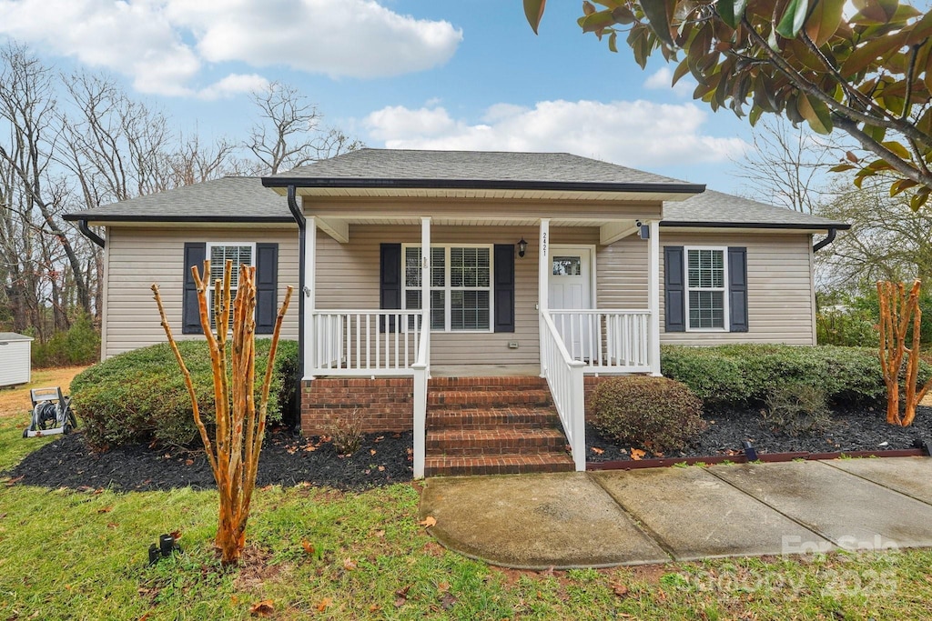 bungalow featuring a porch and roof with shingles